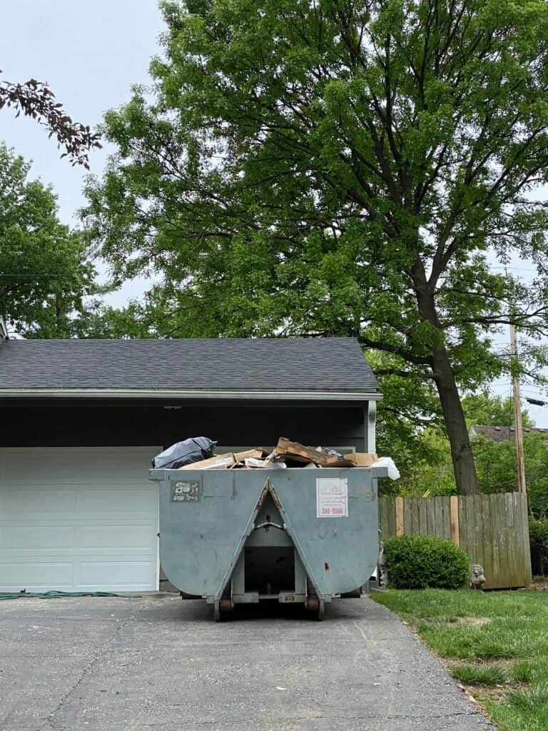 Dumpster for demolition debris in residential driveway.